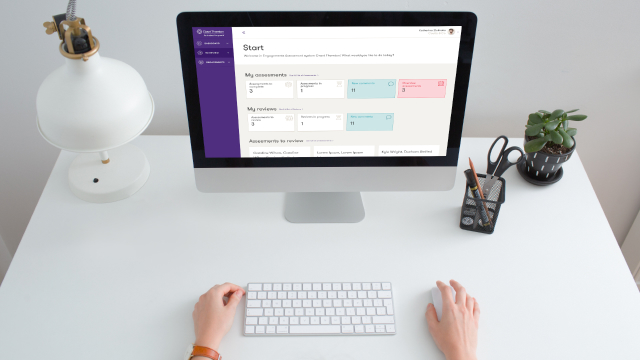 Computer on white desk with Grant Thornton application running