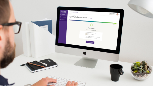 Man with a cup of coffee using Grant Thornton app